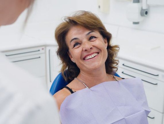 Happy patient looking up at her dentist
