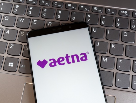 Phone with Aetna dental insurance logo on screen resting on computer keyboard