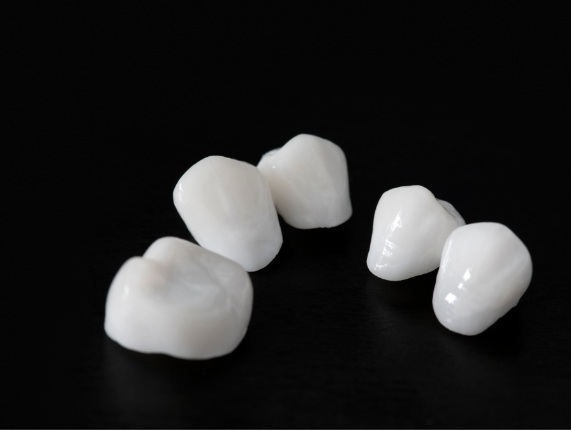 Several metal free dental crowns against black background