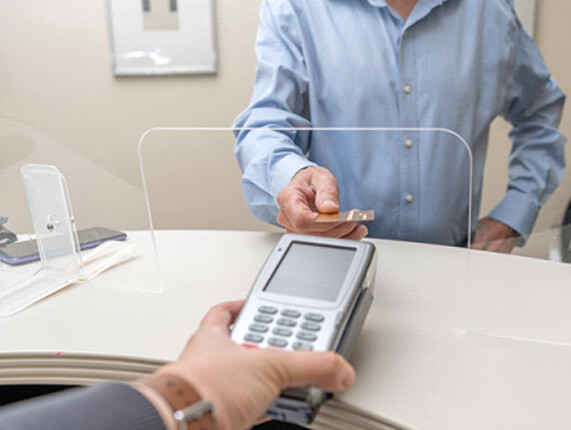 a patient paying the cost of wisdom tooth extractions