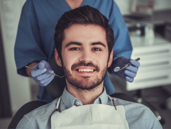 Young man with short beard sitting in dental chair