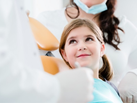 Smiling young girl sitting in dental chair
