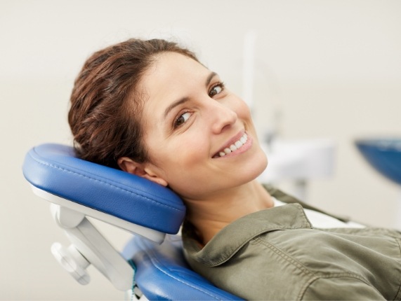 Smiling woman leaning back in dental chair