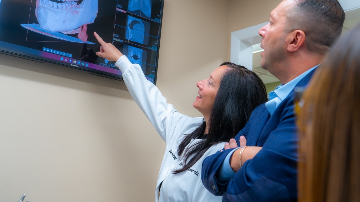 Doctor Gencarelli and Doctor Dawoud looking at digital models of teeth and jaws on computer screen