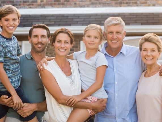 Three generations of a family standing in their front yard