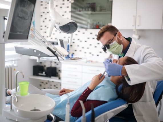 Cosmetic dentist examining a patient before placing dental veneers in West Orange