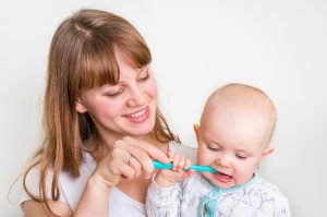 Mother brushing baby's teeth