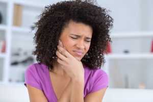 woman with jaw pain who needs to fix TMJ with Invisalign in West Orange 