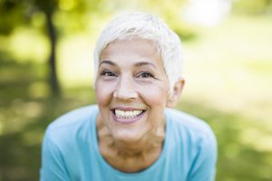 senior woman smiling with dental implants 