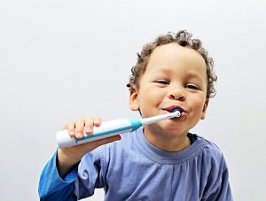 Toodler brushing teeth with toothpaste