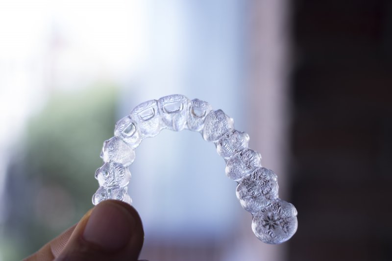 person holding Invisalign aligner