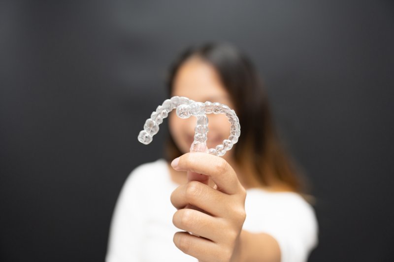 young woman holding clear aligners