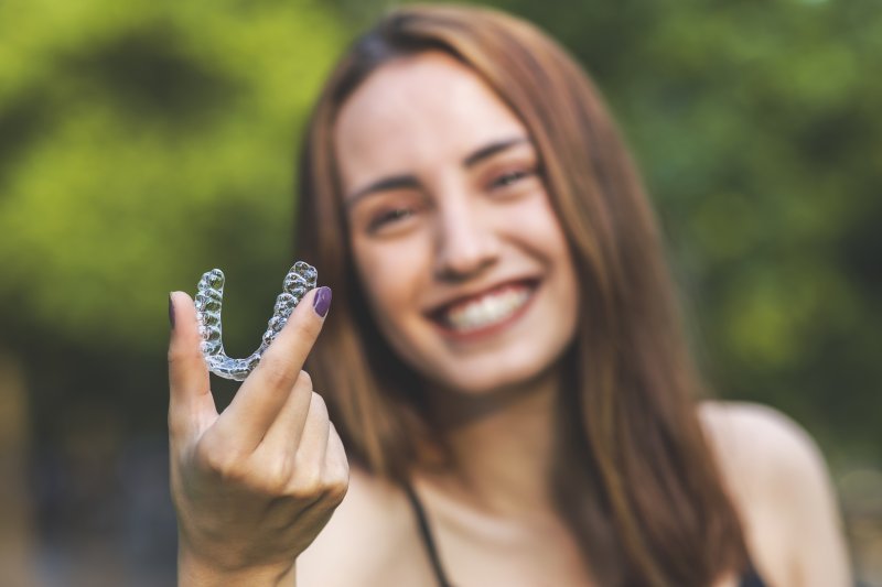 person holding up Invisalign retainer
