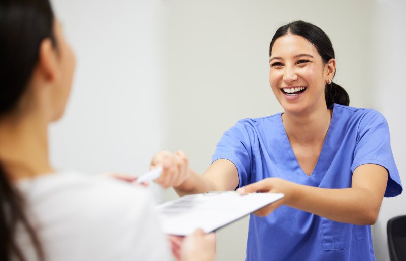 A nurse helping a patient with dental insurance benefits