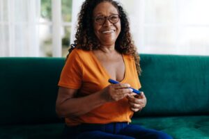 Smiling senior woman checking her blood sugar 