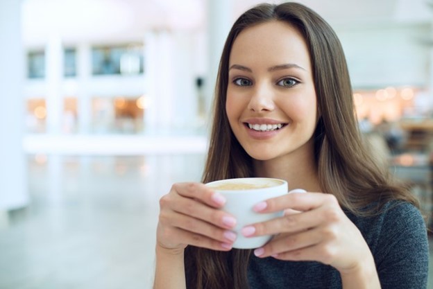 person drinking cup of coffee