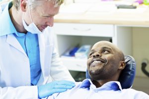 Man in dental chair smiling at dentist