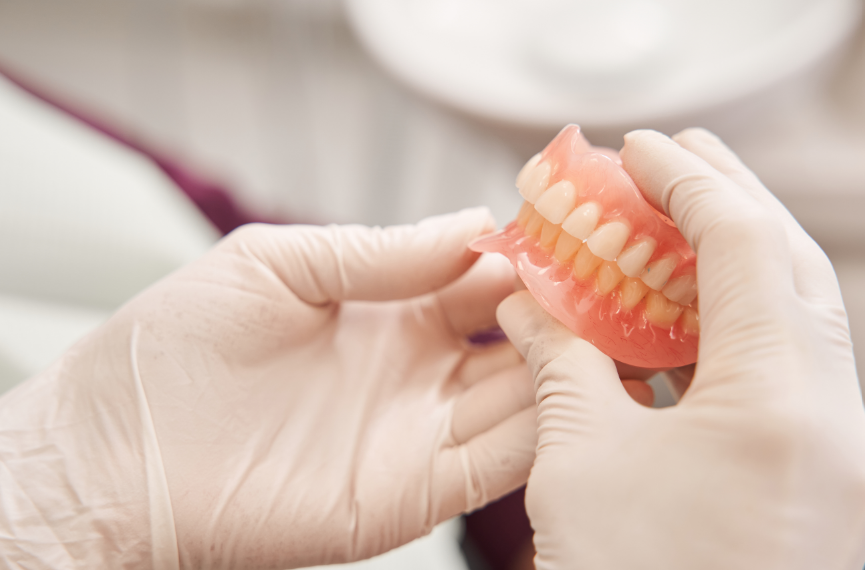 Dentist holding dentures