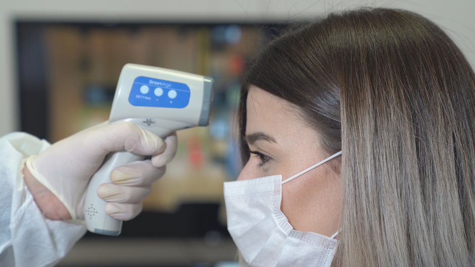 Dentist in West Orange takes a patient’s temperature.