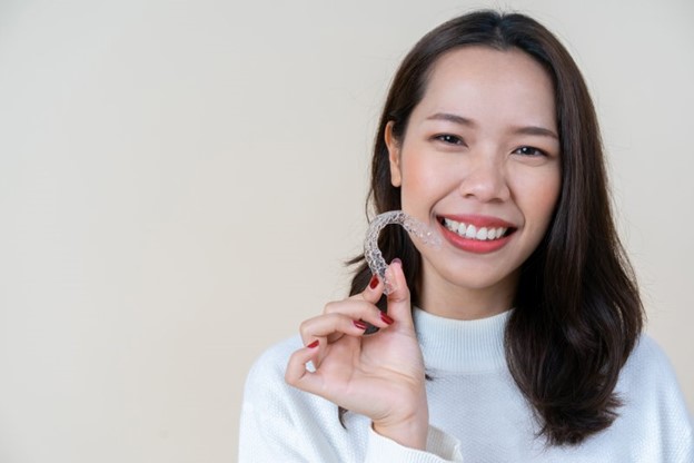 Woman holding her Invisalign tray.